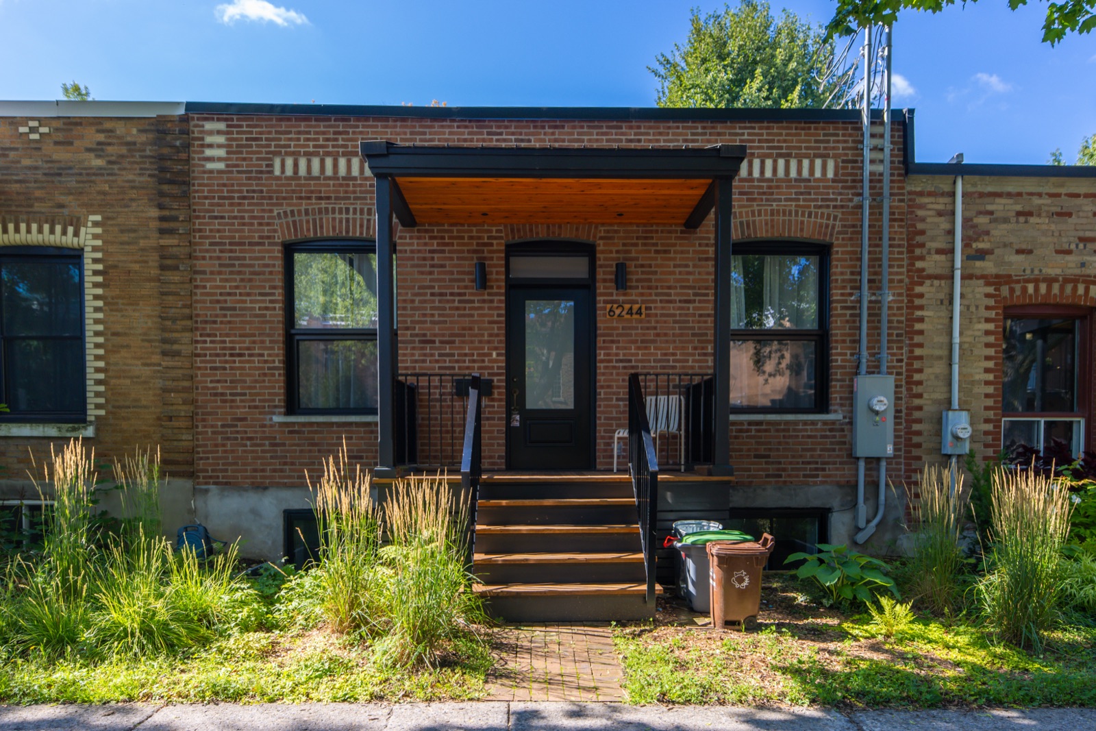Maison shoebox de brique avec auvent d'entrée en bois