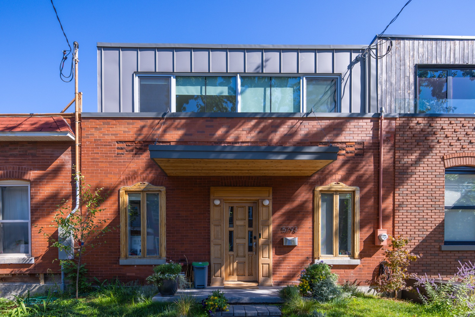 Plex de brique surmonté d'une addition contemporaine à toit plat